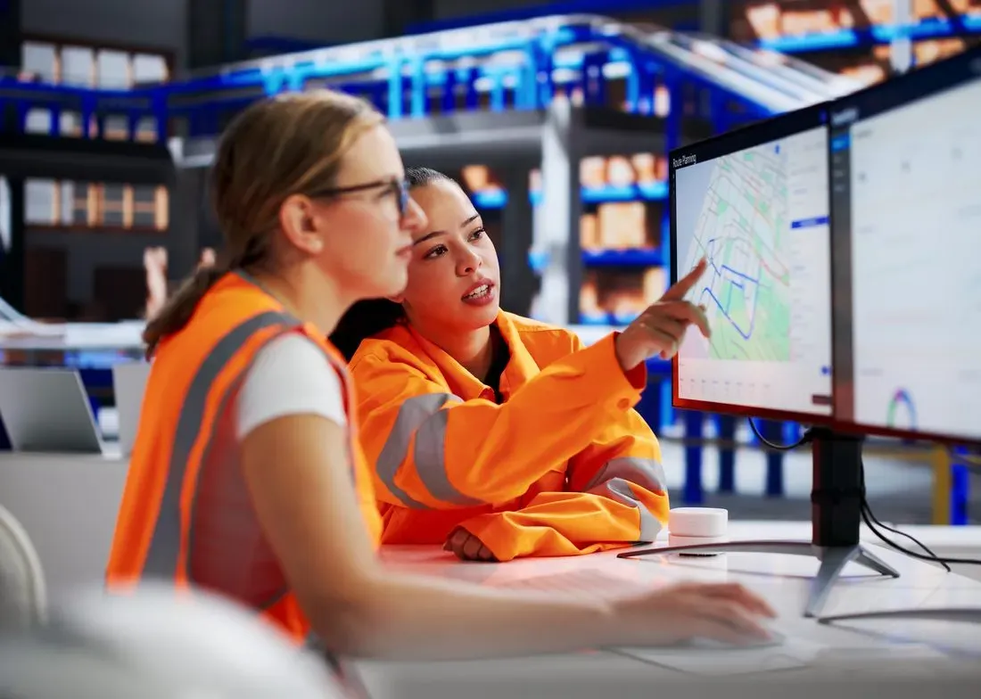 Two transport planners reviewing HGV routes on a route planning screen