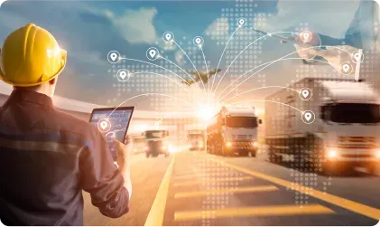 A transport manager with a tablet watching lorries on the road