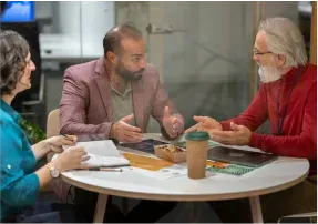 Colleagues talking around a meeting table